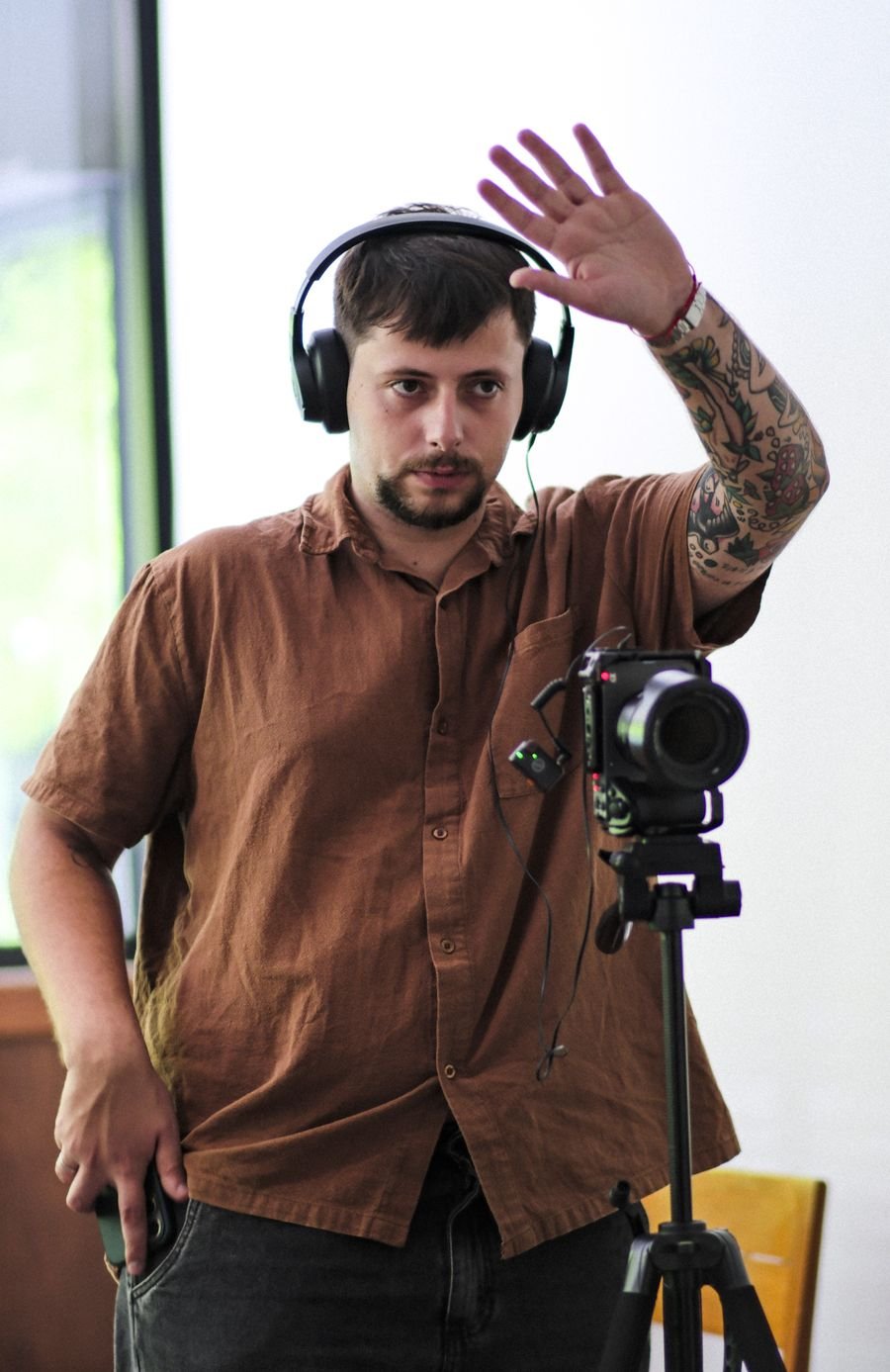 Bruno Faccioli orientando no set, de fone e ao lado da câmera